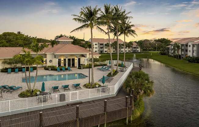 a large swimming pool in front of a house next to a canal