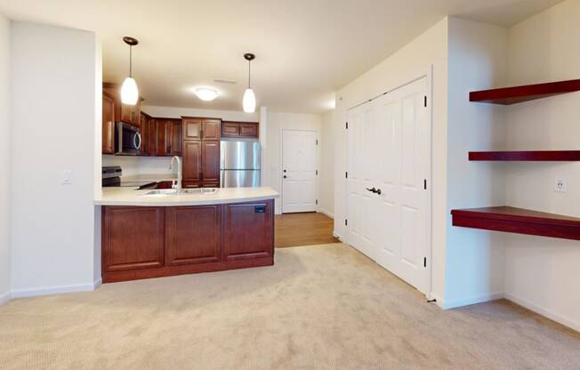 a kitchen and living room with wood cabinets and a counter