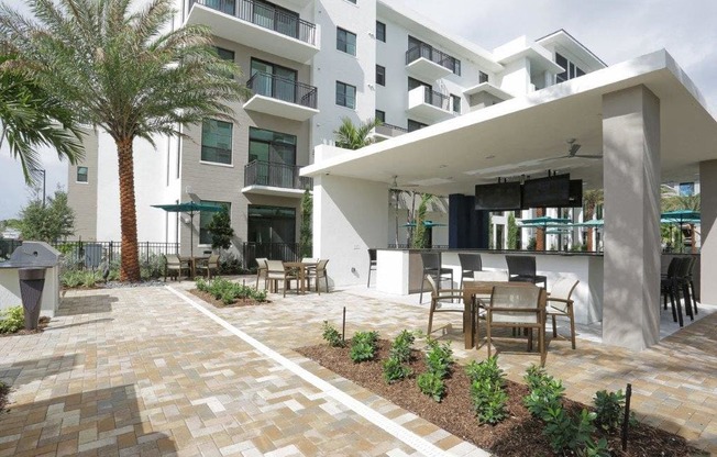 a patio with tables and chairs in front of a building