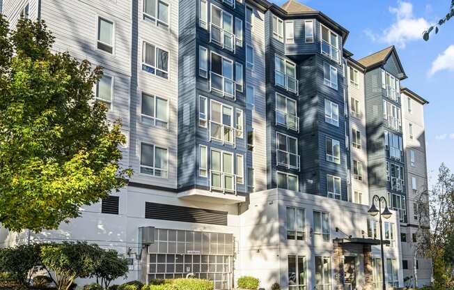 a large apartment building with a tree in front of it