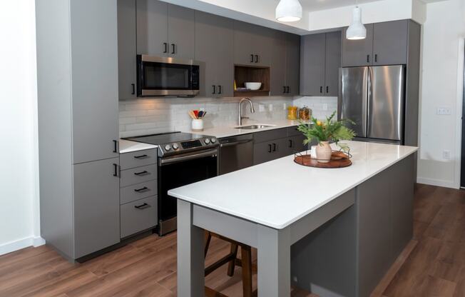 a kitchen with gray cabinets and a white counter top