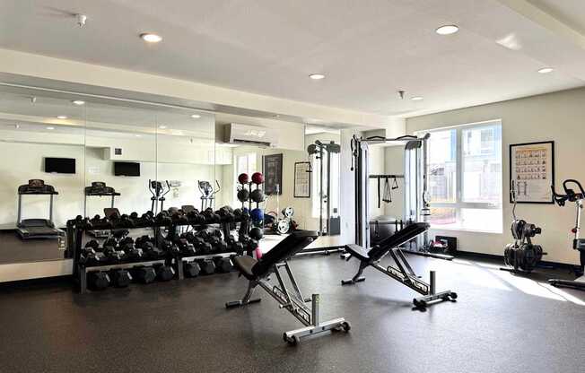 A gym with a variety of equipment including weights and cardio machines at Spyglass Hill Apartments, Bremerton, 98337
