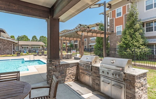 outdoor kitchen with grills and pool area