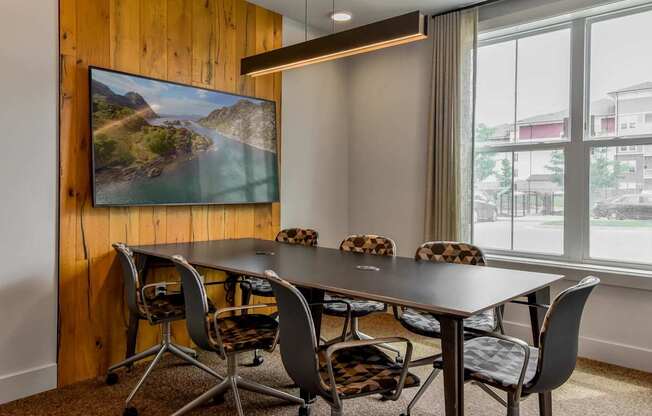 A conference room with a large table and chairs.
