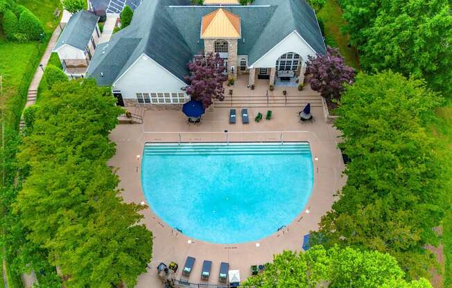 An aerial view of apartment complex with a swimming pool.