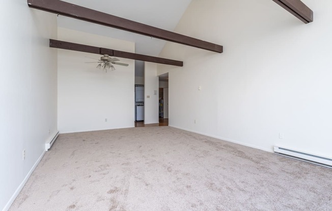 a bedroom with white walls and a ceiling fan