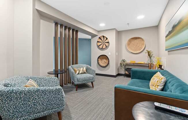 A living room with a blue couch and a patterned chair.