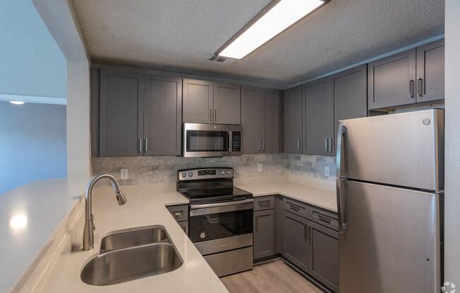 a kitchen with stainless steel appliances and white counter tops