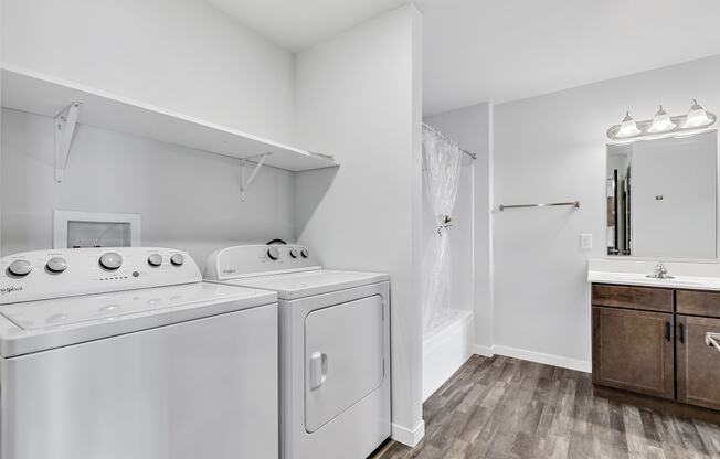 a bathroom with a washer and dryer and a sink