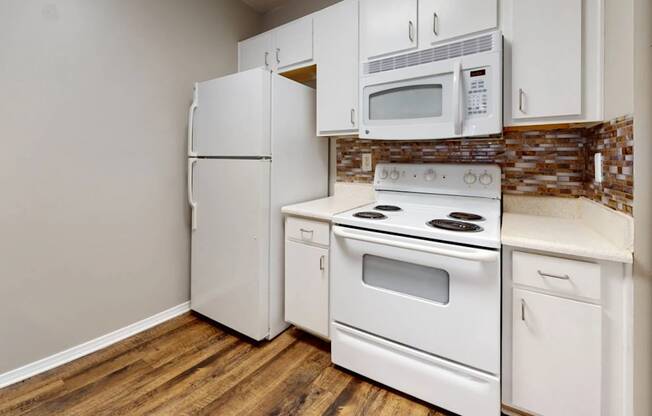 a kitchen with white appliances and a white refrigerator