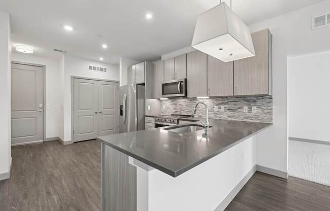 A modern kitchen with a large island and a microwave above it.