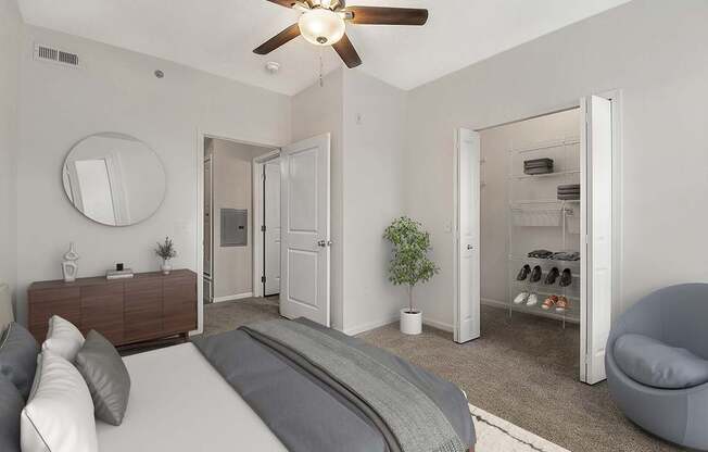 A bedroom with a bed, a walk-in closet, and a ceiling fan at Lynbrook Apartments and Townhomes, Elkhorn, NE, 68022