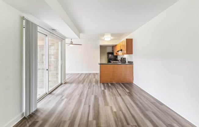 a living room and kitchen with wood floors and a sliding glass door