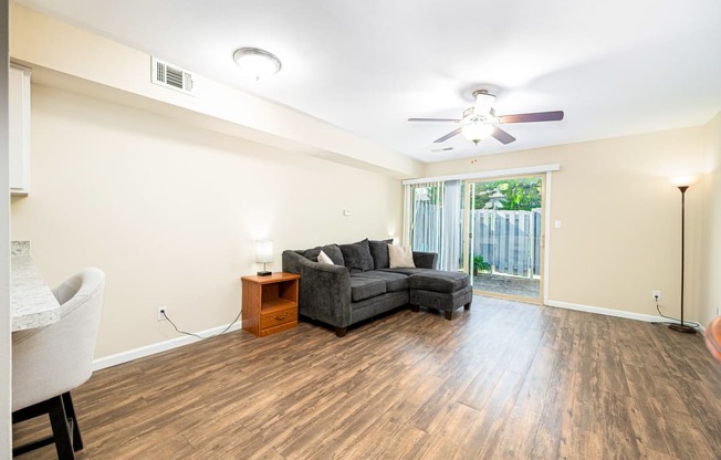 a living room with a couch and a ceiling fan