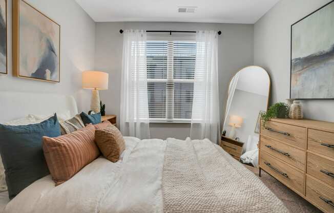 a bedroom with a large bed and a mirror at Preston Ridge, Cary