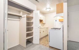 a kitchen with white appliances and a closet