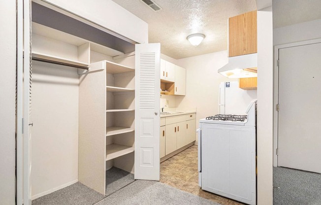 a kitchen with white appliances and a closet