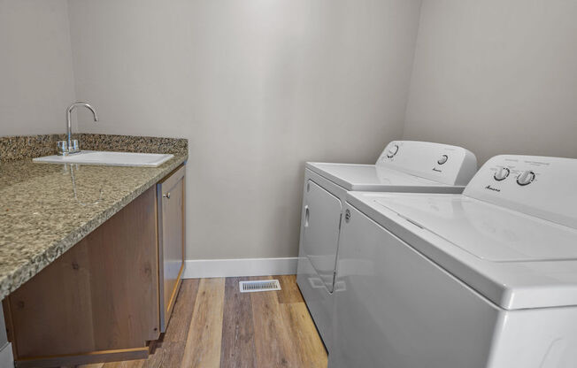 a laundry room with a sink and a washer and dryer