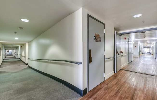 a hallway with white walls and wood flooring