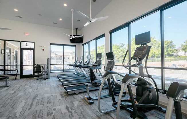 A gym with treadmills and a fan.