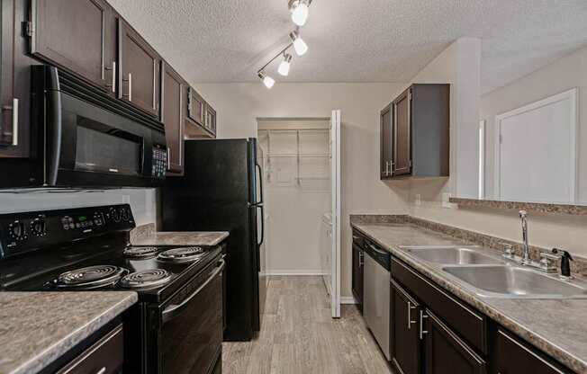 a kitchen with black appliances and granite counter tops