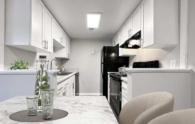 A kitchen with white cabinets and a black refrigerator.