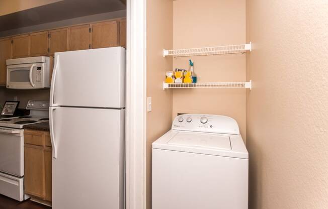 a small kitchen with a washer and dryer and a refrigerator