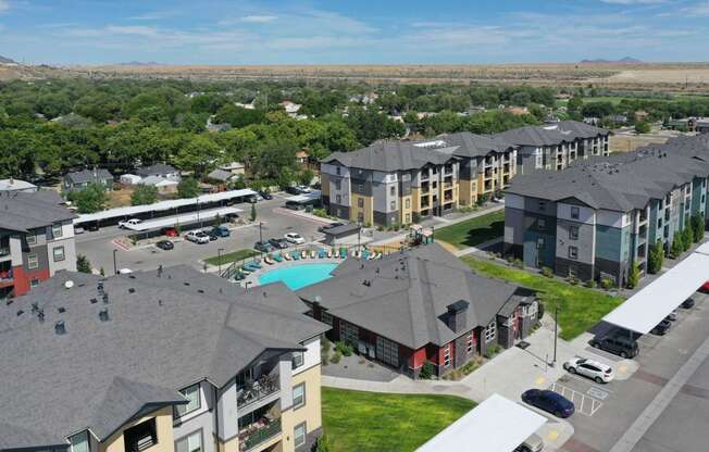 an aerial view of a large apartment complex with a pool and parking lot