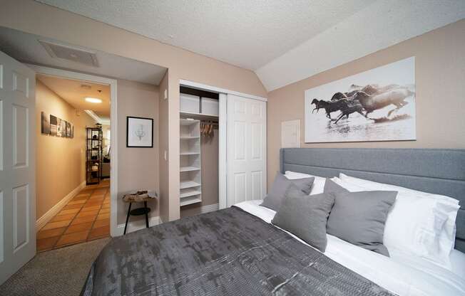 Bedroom in model unit showing spacious closets and berber carpet at the Atrium Apartments in San Diego, California.