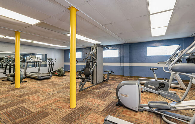 a gym with various machines and weights in a building