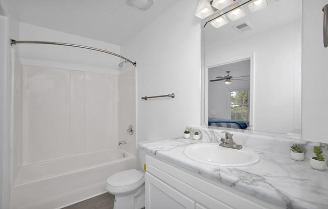 a bathroom with white walls and a white sink and toilet