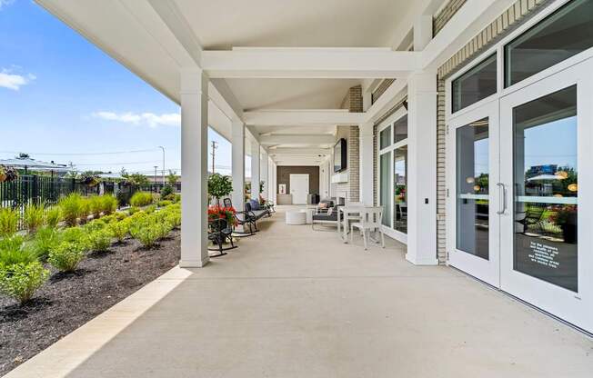 A long white covered walkway with tables and chairs on either side.