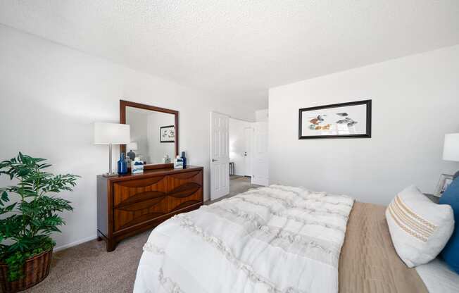 a bedroom with a bed and a dresser with a mirror