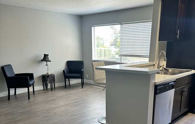 A modern kitchen with a white countertop and a window.