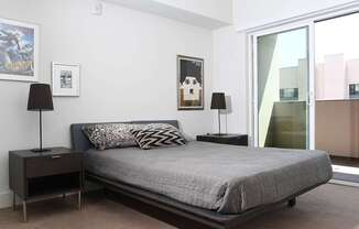 A bedroom with a bed, nightstands, and a poster on the wall.
