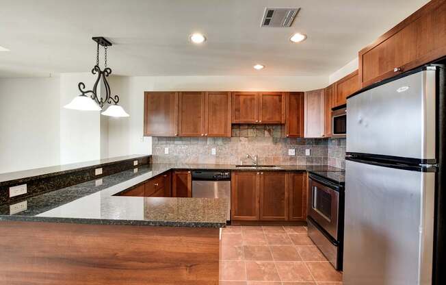 A kitchen with a refrigerator on the right side.