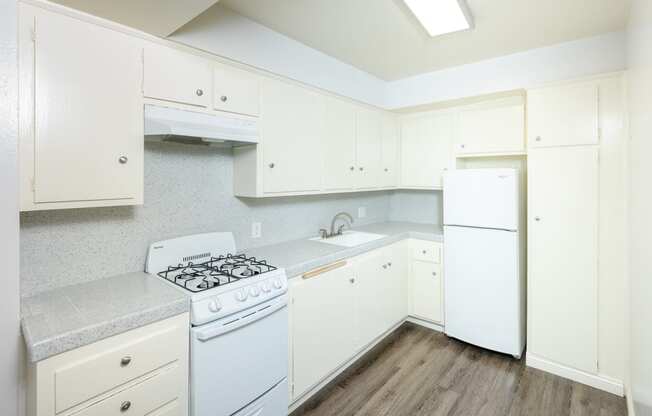 a white kitchen with white appliances and white cabinets