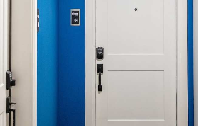 a white door with a black handle in a blue room