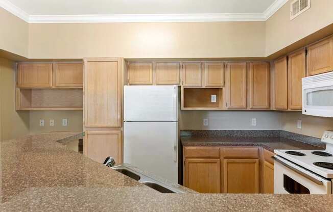 A kitchen with wooden cabinets and a white refrigerator.