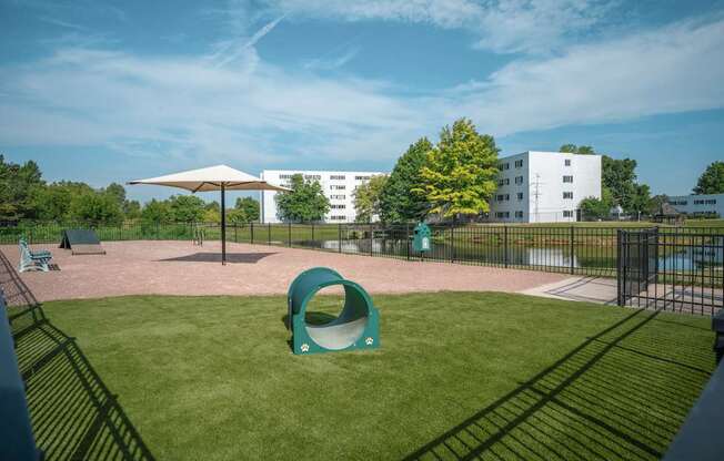 A playground with a green slide and a white building in the background.