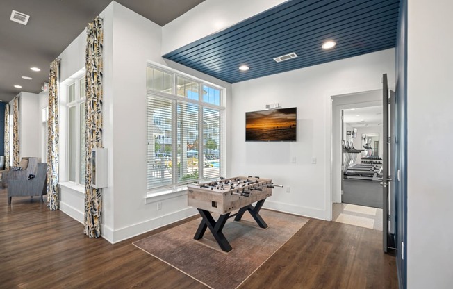 a game room with a foosball table and a window