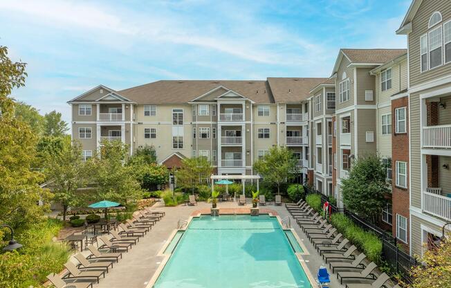 Bird’s-eye view of the pool courtyard reveals expansive sundecks, mature landscaping, and inviting outdoor spaces at the heart of the community.