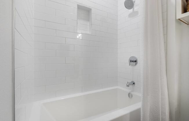 a white bathroom with a shower and a tub