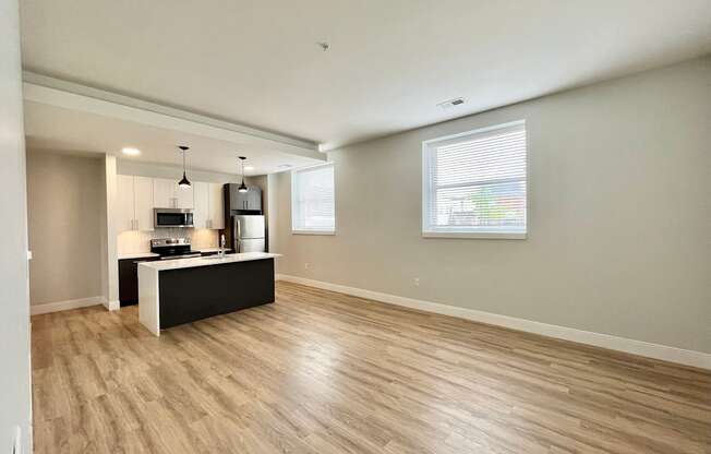 A spacious room with light wood flooring and a black and white counter.