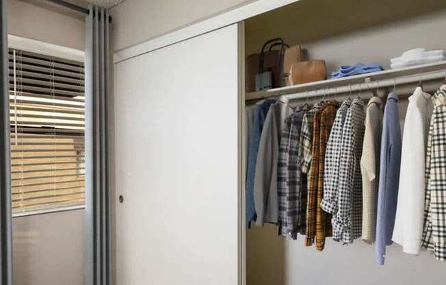 A closet with clothes and shoes.