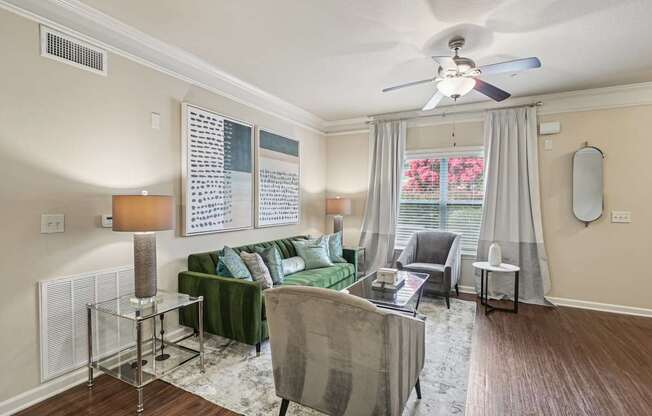 A living room with a green couch and a grey chair.