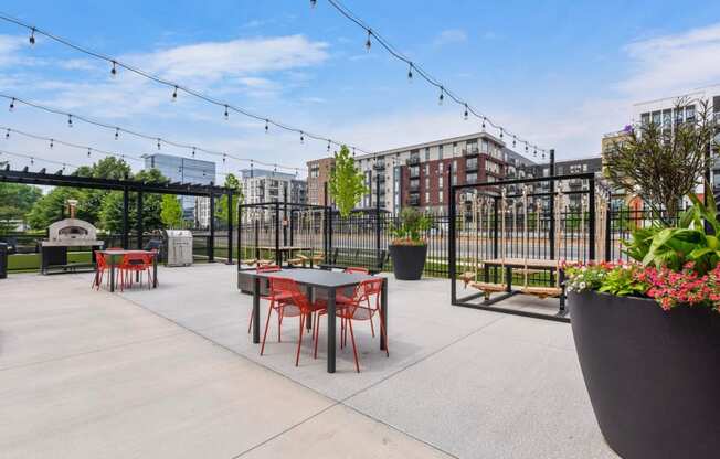 an outdoor patio with tables and chairs and a fire pit