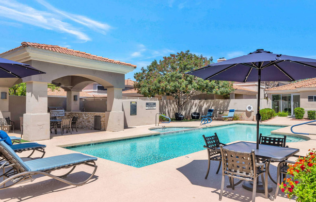 a large swimming pool with umbrellas and chairs around it