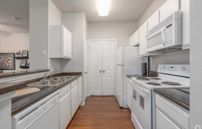 a kitchen with white appliances and counters and white cabinets