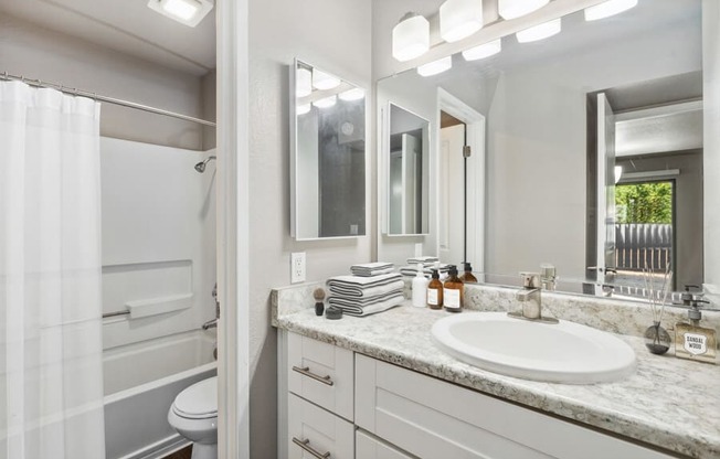 Model apartment bathroom with a sink and a toilet